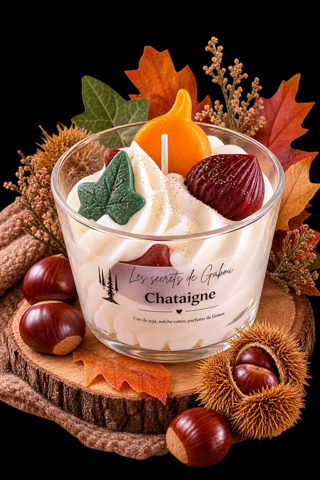 La bougie gourmande Châtaigne : une chantilly de cire ornée d'une feuille et d'une châtaigne, posée sur un rondin entouré de marrons.